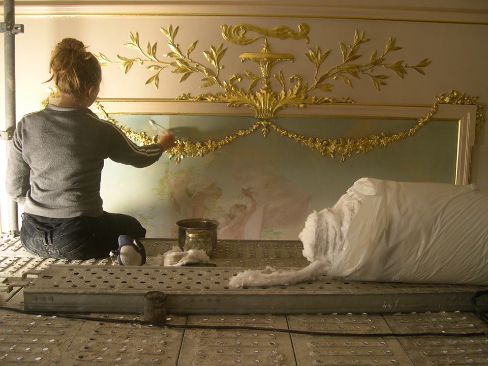 Catherine Hance intervenant sur un grand décor peint et doré